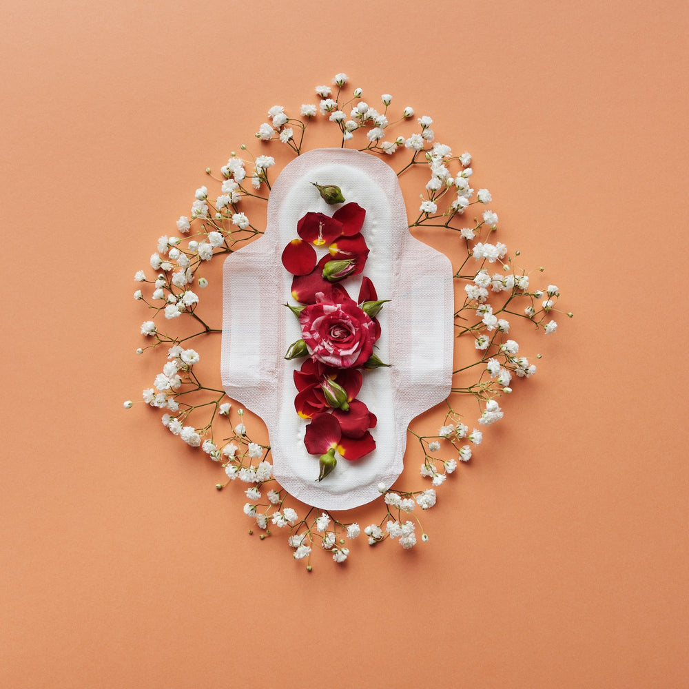 Damenbinde auf orangenem Hintergrund mit roten Rosen drauf und weißen Blumen umrundet
